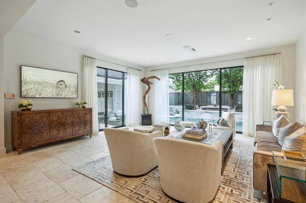 The SUN ROOM (19 X 19) is brightly lit with the diffused outdoor lighting emanating into the space through two sets of 3-panel sliding doors and features travertine tile flooring, recessed/art lighting, ceiling speakers, base molding and designer sheers/rods.  All to enjoy the Backyard oasis!