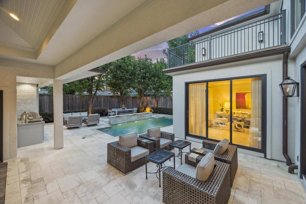 The BACKYARD includes several open Living areas as evidenced with one area just outside the Sun Room and the other on the far side of the Pool with the raised platform accommodating the Dining space -  all close to the covered Summer Kitchen and the pool with its dramatic stone wall with decorative water features.
