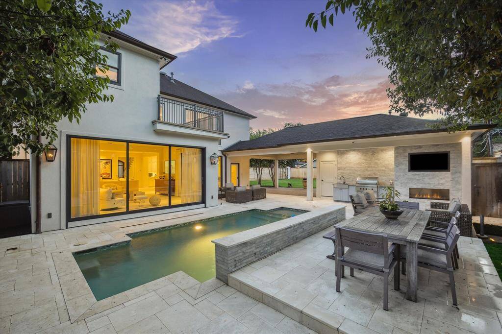 Closer view of the raised platform of the outdoor dining space just behind the decorative water feature.  Also take note of the expansive window panels from the Sun Room opening out to the relaxing Backyard oasis.