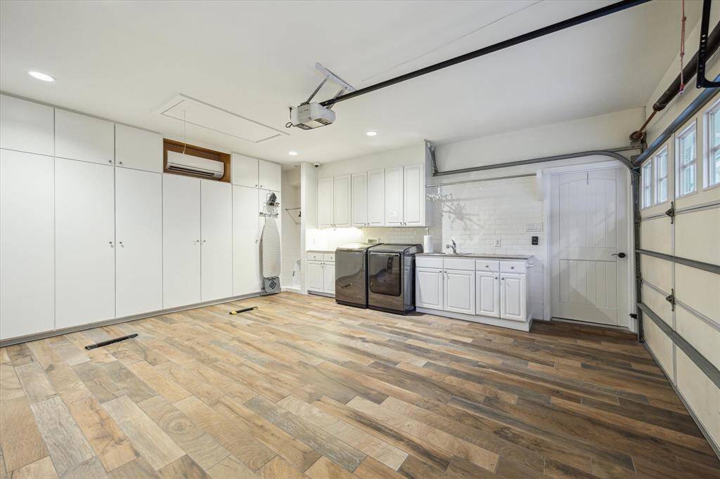 The interior of the 2 CAR GARAGE is appointed with its own AC system, tile flooring and Utility Station with its granite countertop/subway tile backsplash/sink/clothing dry station/wall of storage cabinetry.