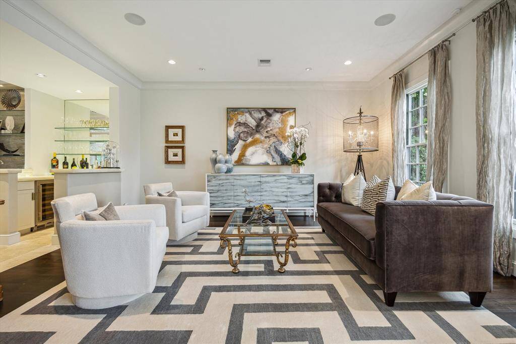 What an entertaining space - the LIVING ROOM (17 X 15) with its wide plank flooring, painted walls, crown/base molding, recessed/art  lighting, ceiling speakers, oversized mullioned windows with designer rods/drapery and close proximity to the adjacent WET BAR.