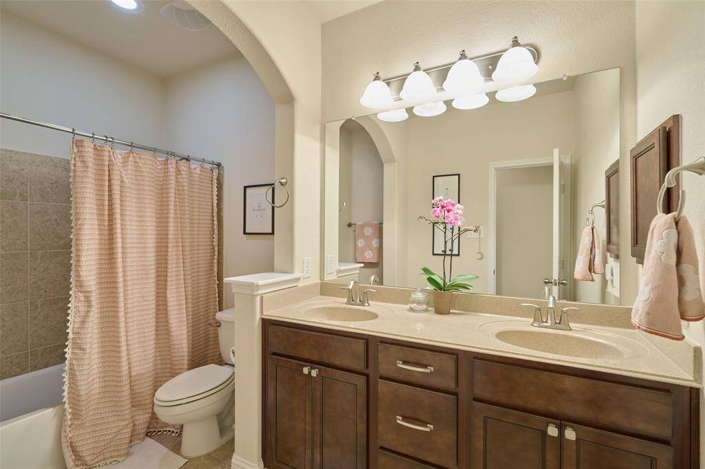 1st full bathroom downstairs featuring dual sinks and tub/shower combo.