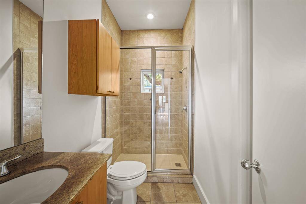 Full bathroom with granite countertops and stand alone tiled shower.