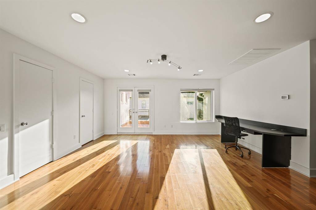 Game room with closets, wood floors, balcony access and more natural light!