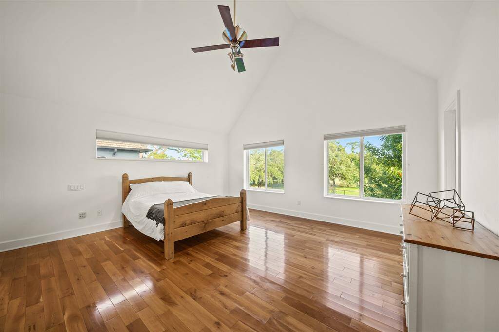 Spacious primary bedroom with tree top views.