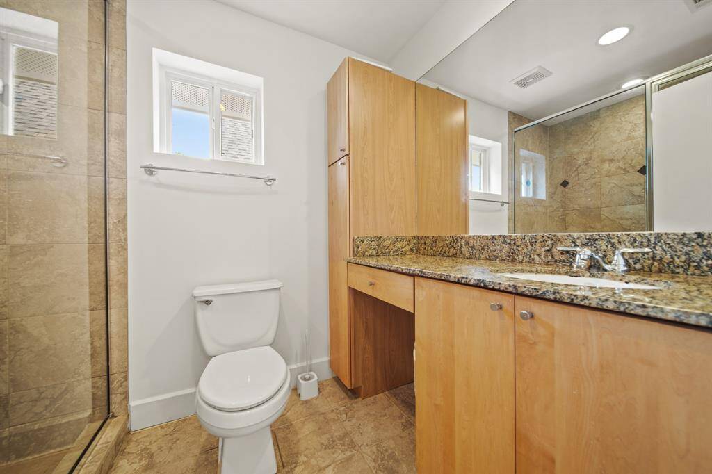 Attached bathroom with upgraded countertops, stand alone shower and lots of cabinets.