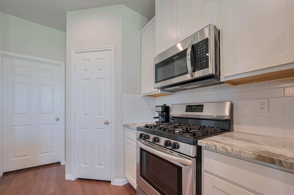 The polished granite countertop pairs beautifully with a subtly textured white backsplash, creating a clean and cohesive look.