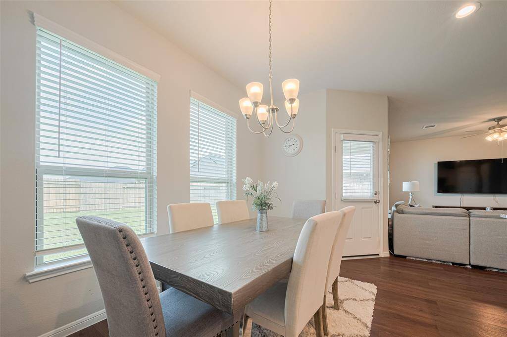 A view of the dining area opposite a glass-paneled door that leads to the backyard—blending indoor and outdoor living with ease.