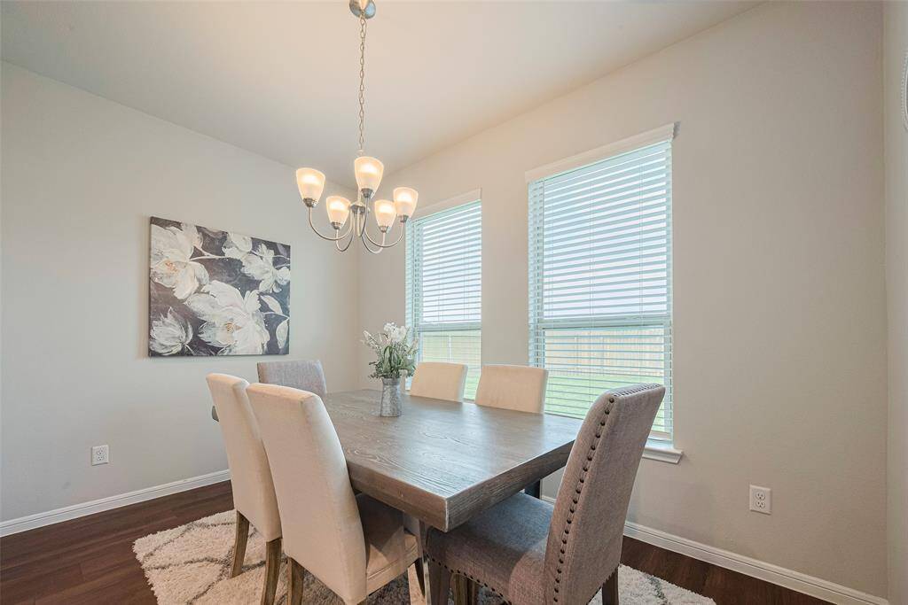 Light pours into this dining corner, where a minimalist chandelier adds a contemporary touch to the cheerful ambiance.
