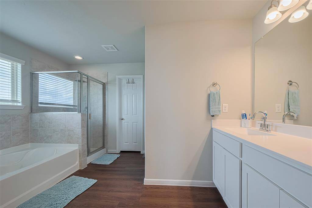 The en suite bath is expansive, with a dual-sink vanity, soaking tub, and separate shower.