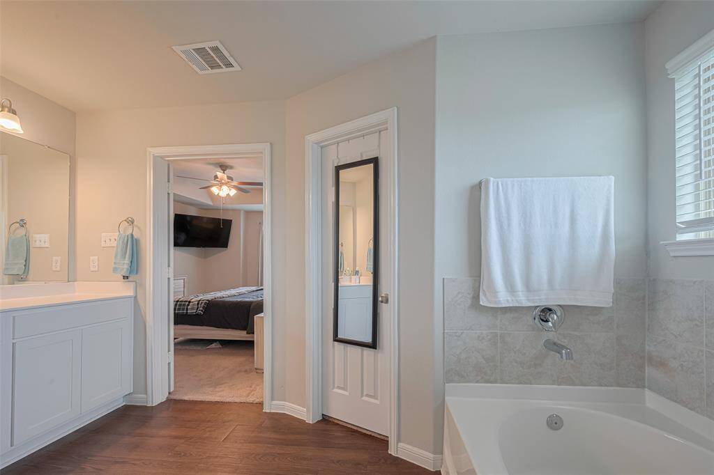 From the bathroom, a glimpse into the bedroom reveals the sense of privacy and openness offered by double doors.