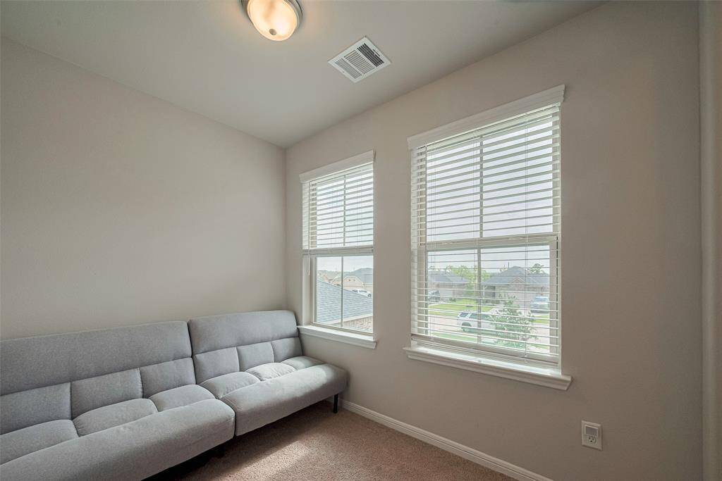 This carpeted loft area offers a blank canvas—perfect for a media lounge, creative studio, or home office.