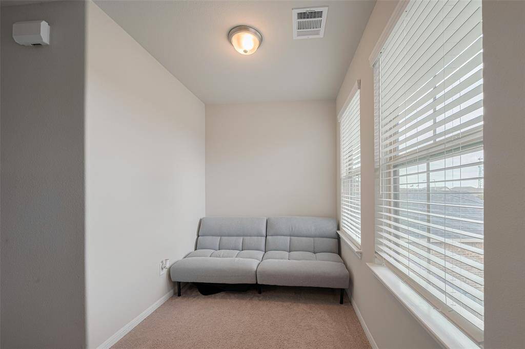 Generous windows brighten the upstairs loft, providing a peaceful space to unwind or focus.