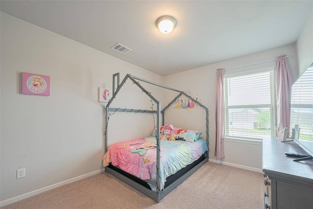 Carpeted and spacious, this room is filled with natural light from a large window—perfect for rest, play, or study.