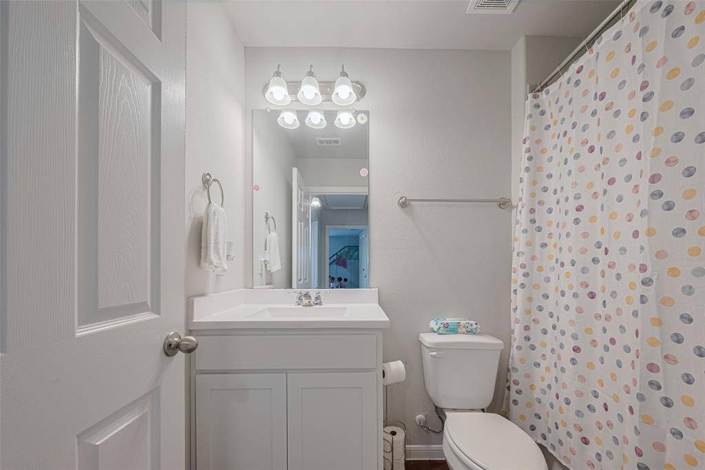 A tub-and-shower combo is paired with a crisp vanity in this full bathroom.