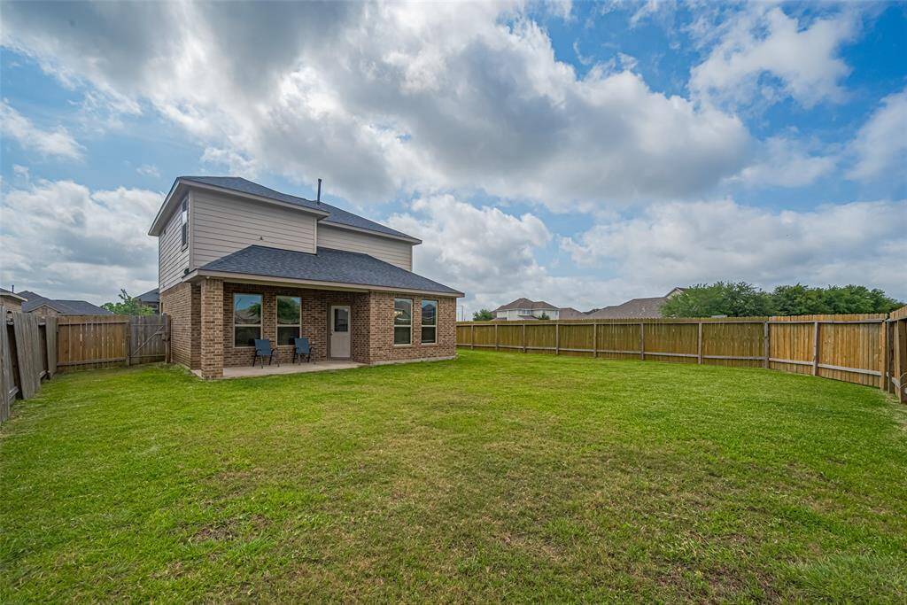 The shaded patio space is perfect for lounging or outdoor meals, tucked into a recessed nook at the back of the house.