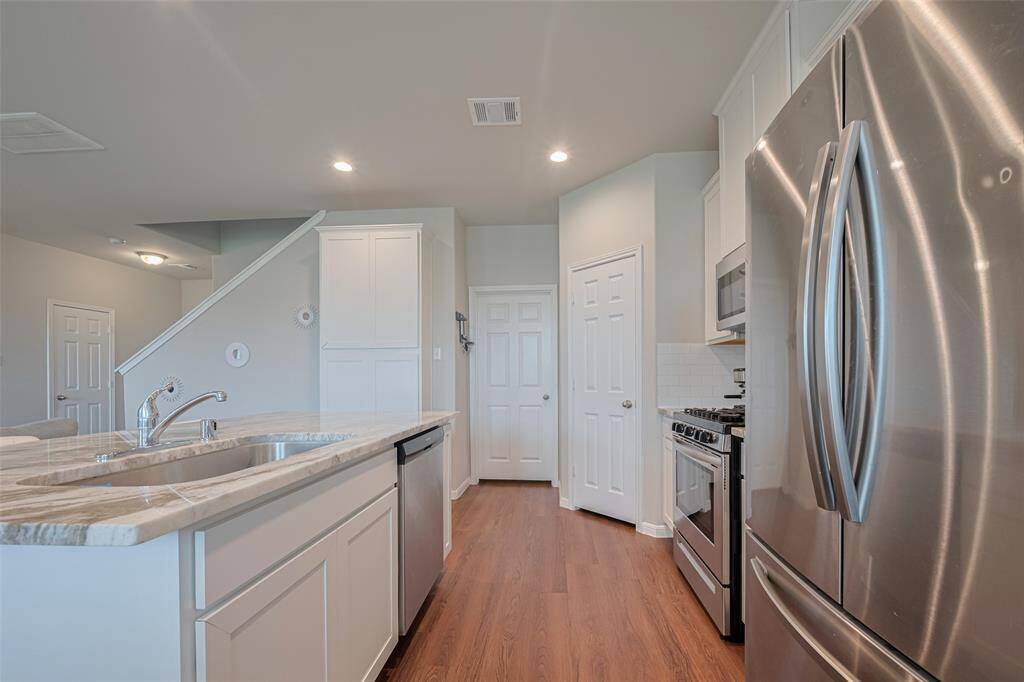 Modern stainless steel appliances—including a sleek dishwasher—bring a professional edge to the culinary space.