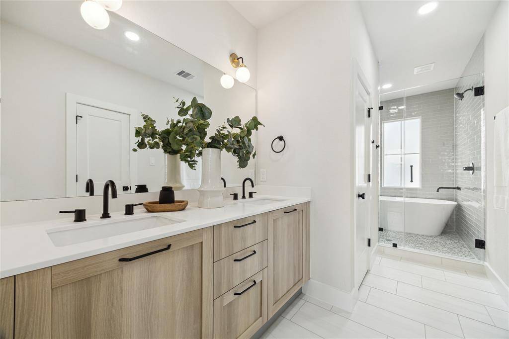 Luxurious primary bathroom featuring a spacious double vanity, elegant fixtures, and a serene soaking tub for ultimate relaxation.
