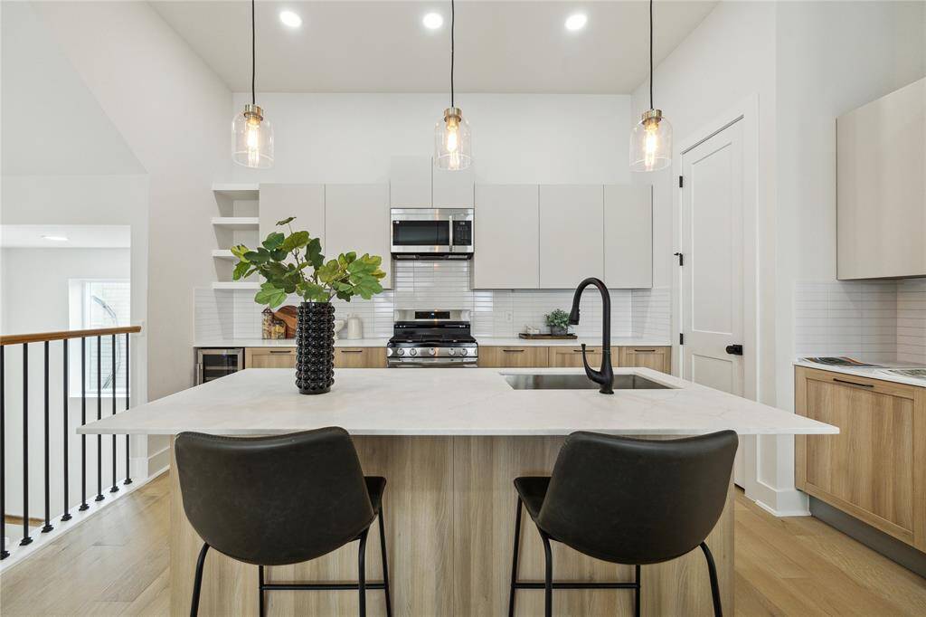 Modern kitchen featuring sleek cabinetry, stainless steel appliances, and an inviting island with stylish pendant lighting. Ideal for cooking and entertaining.