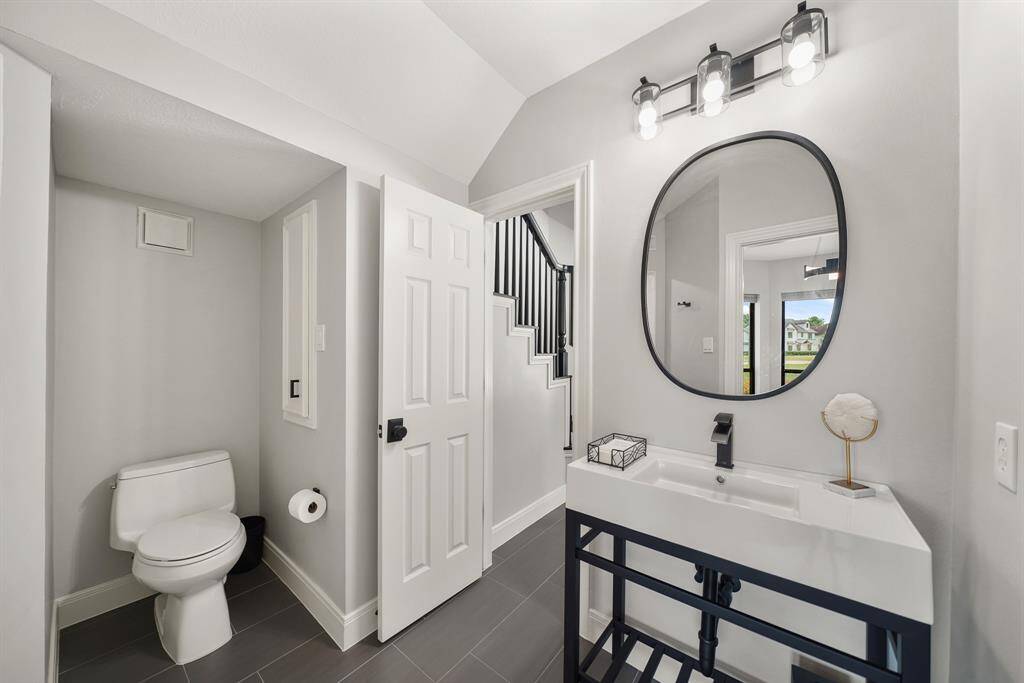 This Full Bathroom is accessible from both the Study and the Family Room. The space comes equipped with an art deco inspired vanity with an undermount sink, framed mirror, built-in storage cubby, and floor-to-ceiling subway tiled, frameless shower.