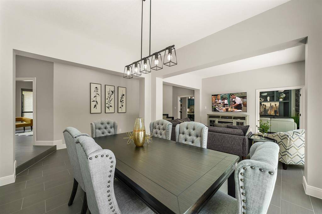 The Formal Dining Room boasts a modern, 5-light chandelier, tile flooring, and wall of sliding glass doors with a desirable view. This open concept layout makes entertaining groups both large and small manageable and fun.