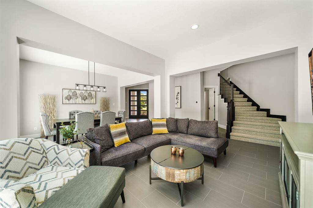 The Family Room is centrally located within the home and can accommodate a multitude of seating options. The stairs ahead lead to 3 Secondary Bedrooms and a spacious Game Room.