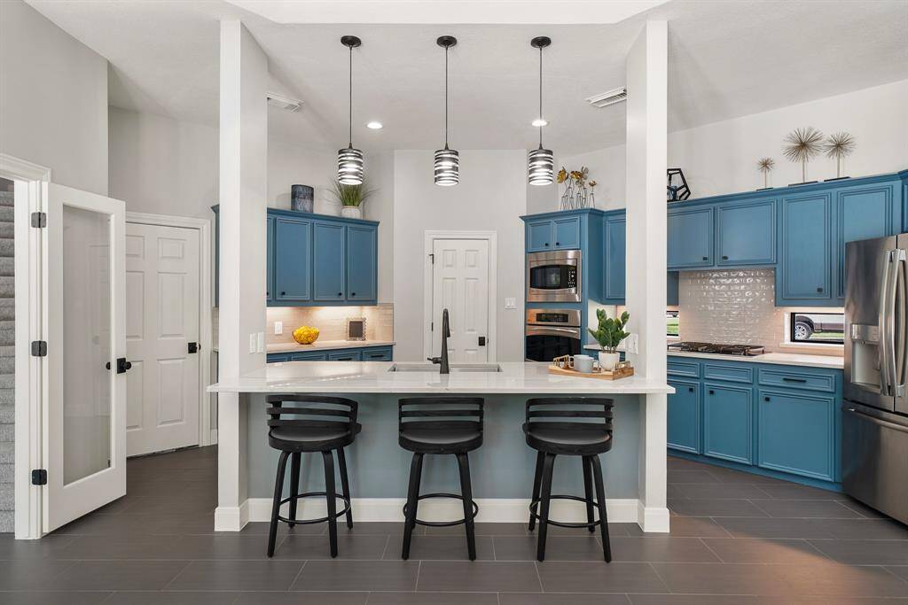 Additional seating can be found at the Kitchen Island, providing a perfect place to eat breakfast while watching cartoons. The island remains well lit thanks to the trio of pendant light above.