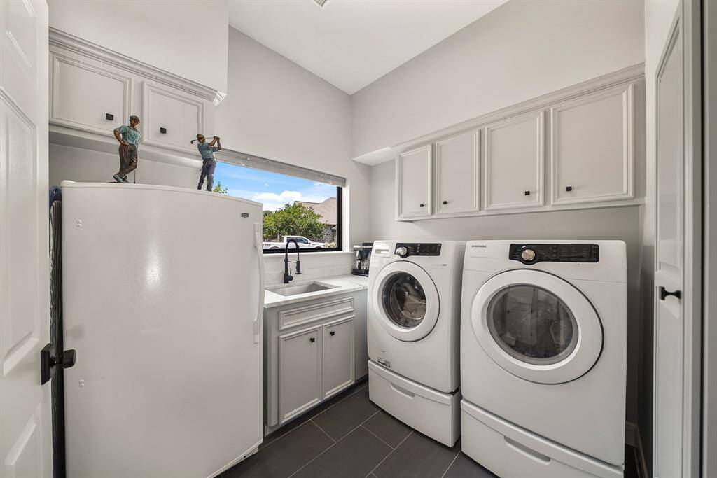 The Laundry Room is located between the Breakfast Room and the Kitchen. The space includes a stainless steel, undermount sink with detachable spray nozzle, quartzite countertops, space for a refrigerator or freezer, and an abundance of closed storage. Tackling tough stains will be a breeze with this well thought out setup!