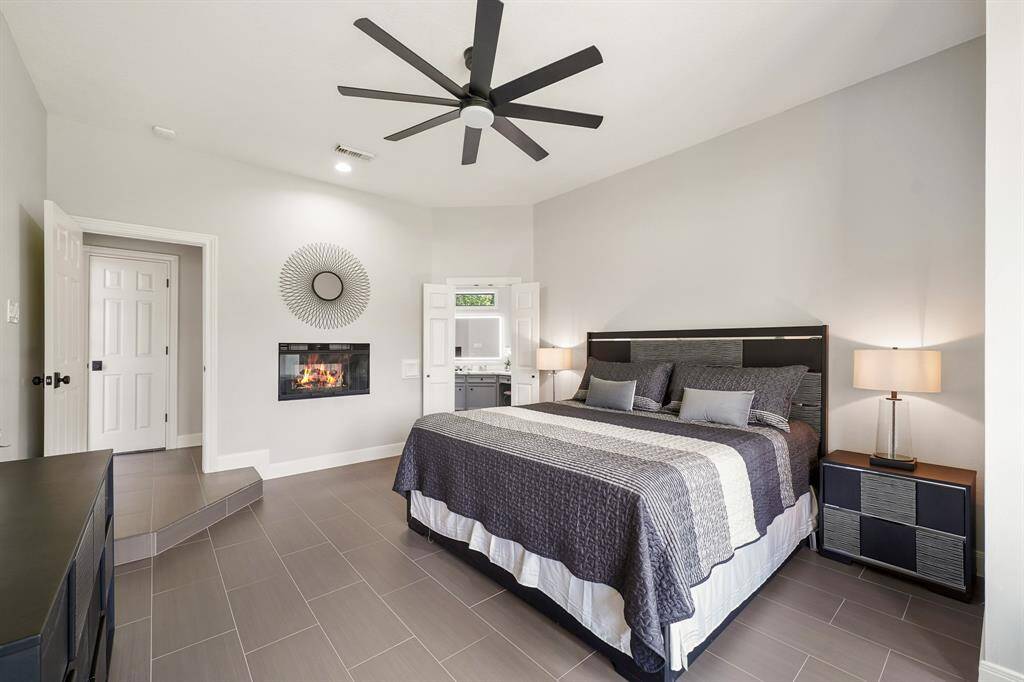 : The Primary Retreat is located down a private hallway off the Foyer. Unique to the space is a double-sided, gas-log fireplace that is enjoyed from the Primary Bedroom and Bathroom. The double doors ahead lead to the ensuite Bath.