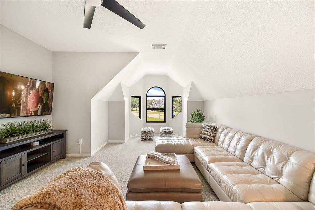 The Game Room, located at the top of the stairs, includes plush carpeting, a storage closet, 5-blade ceiling fan, and a trio of windows overlooking the Front Yard. This home is unique in that many of the rooms boast heavily angled walls and ceilings, adding detail and character to the home.