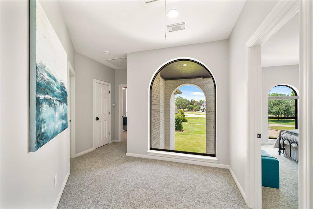 This large and inviting second floor landing separates the Game Room and previously seen Secondary Bedroom, from the two additional Bedrooms across the way. This floor-to-ceiling, arched picture window overlooks the two-story front entryway, making this the perfect spot to set up a pair of chairs or a small study desk.