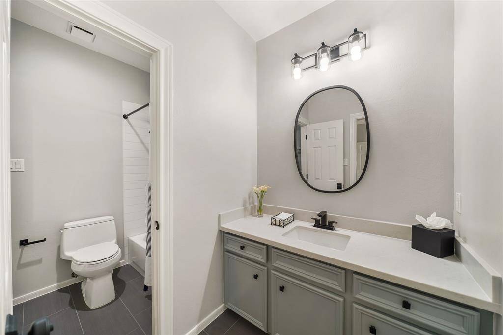 Two Secondary Bedrooms have direct access to this Jack and Jill Bathroom. Both rooms have their own quartz topped vanity with an undermount sink, framed mirror, and matte black hardware. Doors separate the subway tiled shower/tub combo and toilet, allowing two people to get ready at the same time.