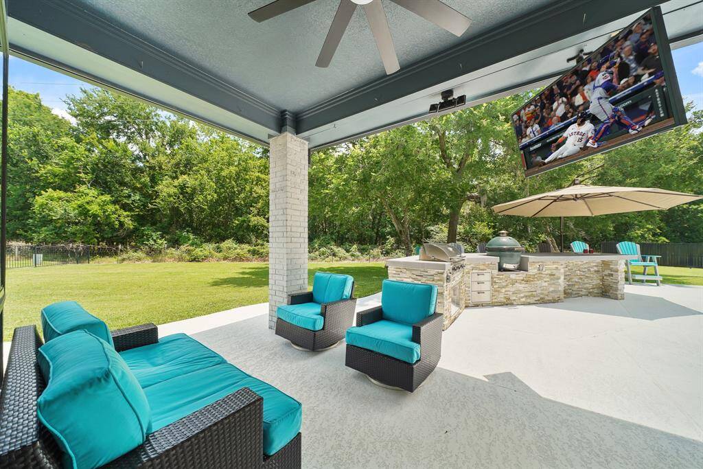Enjoy the peace and quiet this tree-filled Backyard has to offer under the comfort of this spacious, fully covered Back Patio. The space boasts brick pillars, tv hookup, and an oversized ceiling fan to keep cool during the summer months.