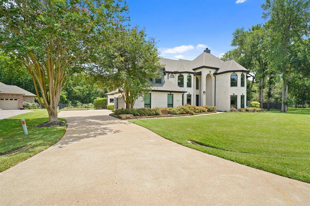 The oversized driveway leads to the home’s 3-car attached Garage. Two mature crepe myrtle trees provide a dappling of shade over the driveway and a pop of color every summer.