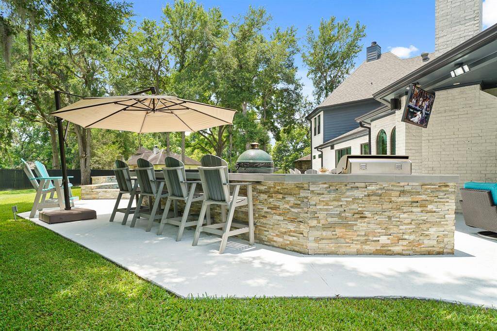 Additional seating can be found on the other side of this stacked stone Outdoor Kitchen. This is the perfect place to sit down and grab a bite before jumping back into the Pool.