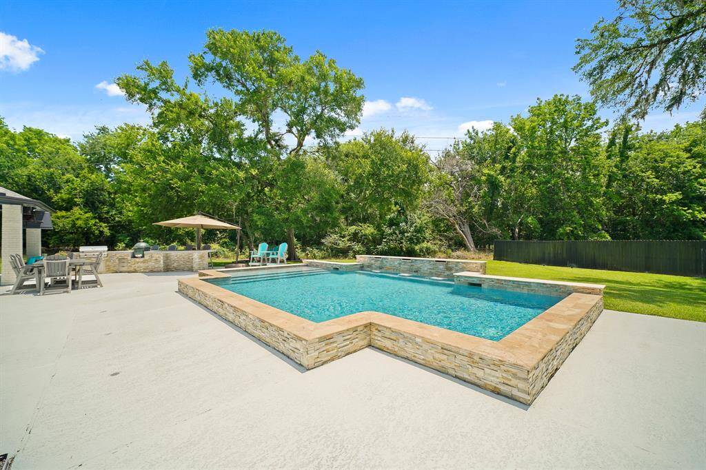 The stamped concrete pool decking provides a cool and slip-free patio surface. Add a few lounge chairs and umbrellas and there is no reason to leave this spot all summer long.