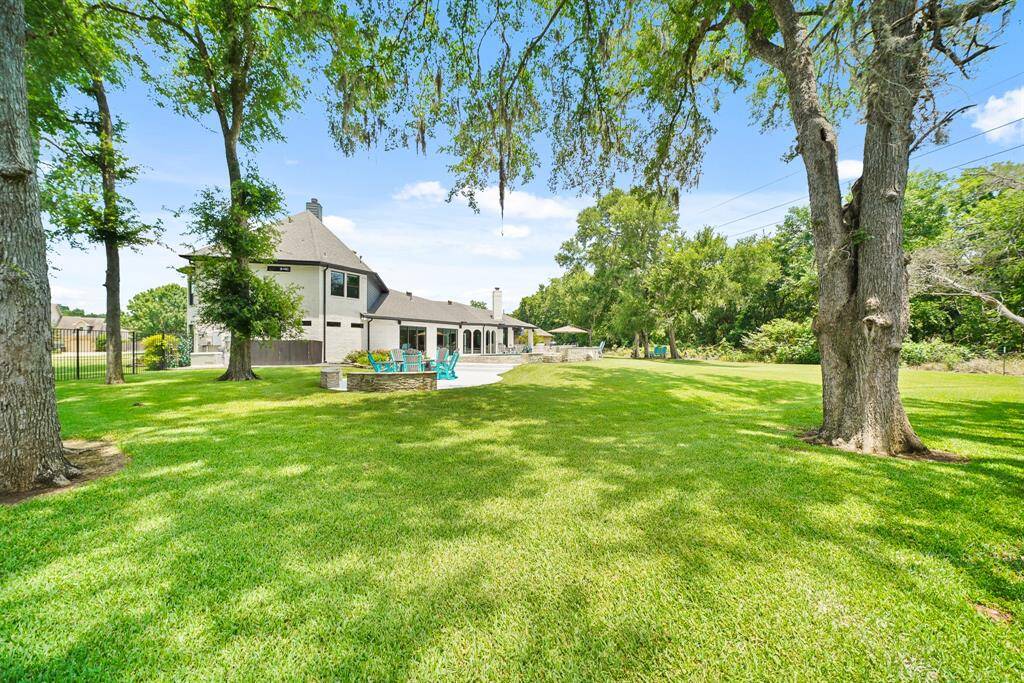Even with an Outdoor Living Space, Dining Space, Kitchen, and Pool, there is plenty of lush yard space for kids to play and dogs to run. This beautiful tree-lined Backyard Oasis is where friends and family will want to gather and make lasting memories year after year.