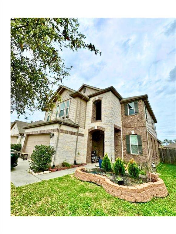 This two-story home features a combination of brick and stone exterior with a covered entryway. It includes a two-car garage and a well-maintained front yard with a small landscaped area.