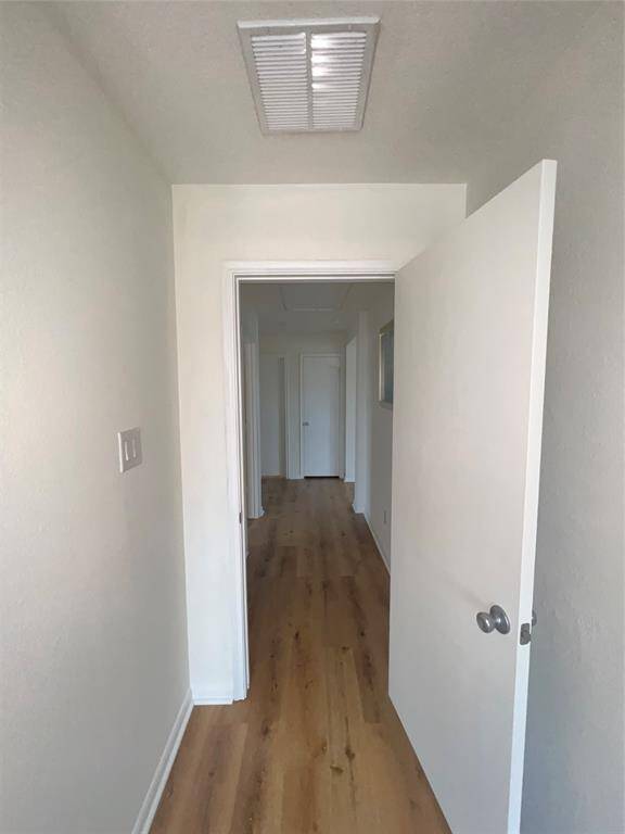 Bright hallways with light walls and wood laminate flooring.