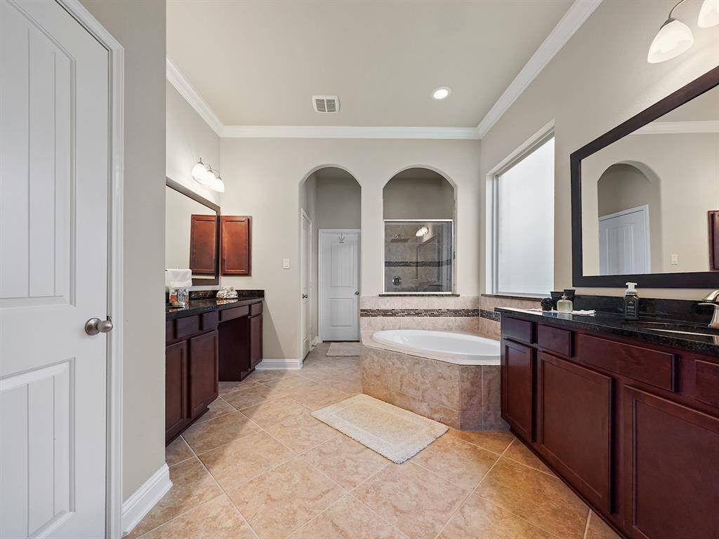 Separate sink areas, vanity, soaking tub and walk-in shower complete this spa-like bath.