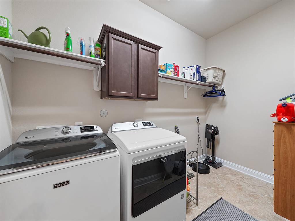 Utility room in house with built-in cabinet and clothing racks.