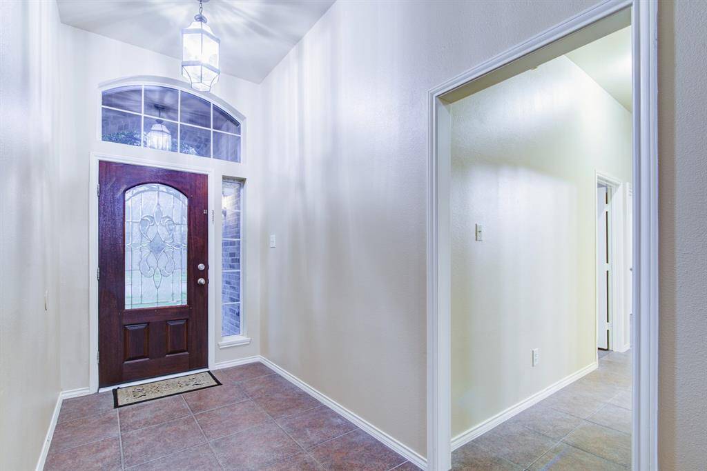 Beautiful beveled glass entryway. The hall way at the front of the home leads to three additional bedrooms and a Hollywood Bath connected to one of the bedrooms. Fun Fact: The difference between a Hollywood bath and a Jack & Jill bath is that a Hollywood bath connects a bedroom to a hallway. A Jack & Jill bath is a bathroom between two bedrooms.