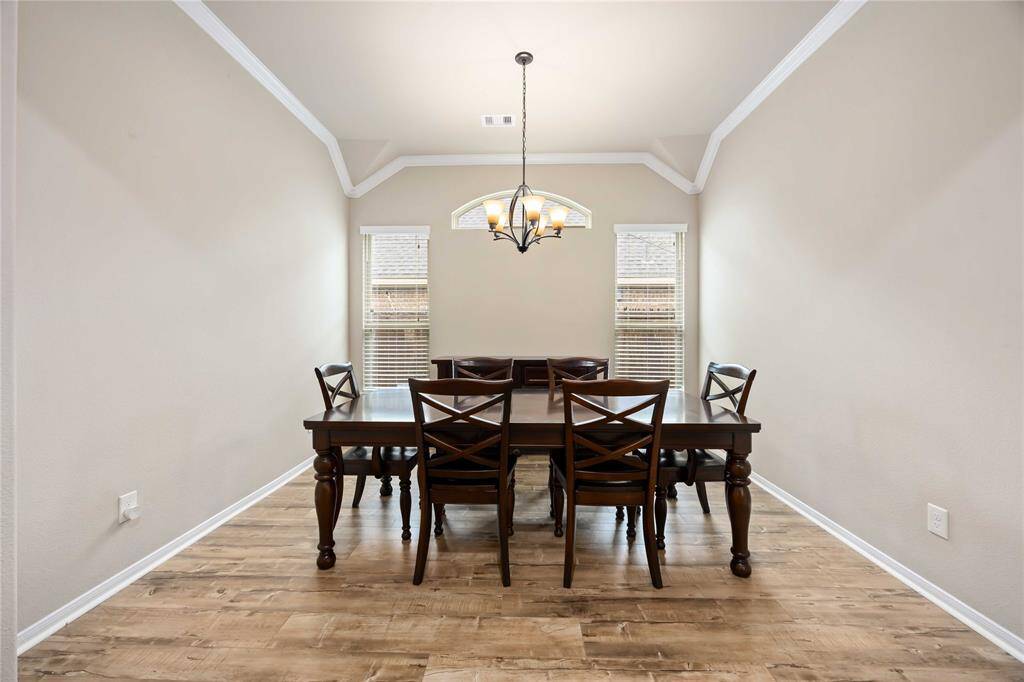 Formal Dining features beautiful crown molding, tall windows & a classic chandelier.