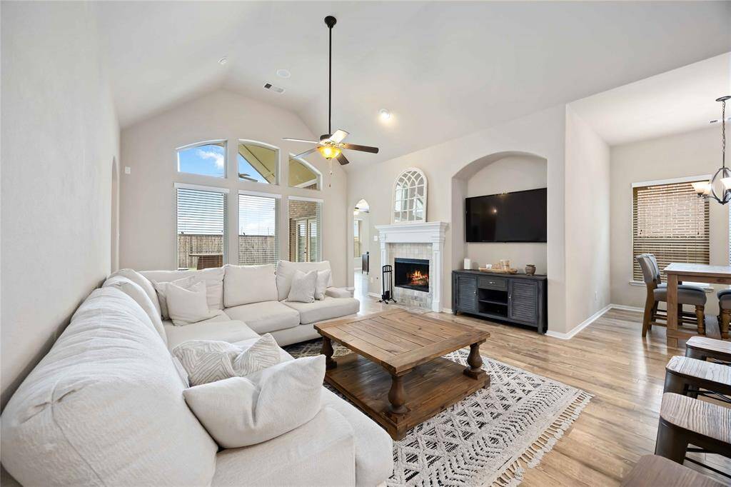 This expansive living room features beautiful flooring and a soaring ceiling.