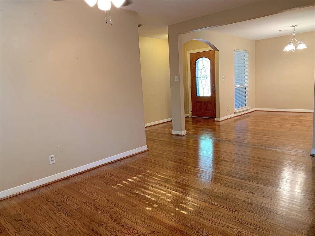 View of open living and dining areas looking towards front entry hall.