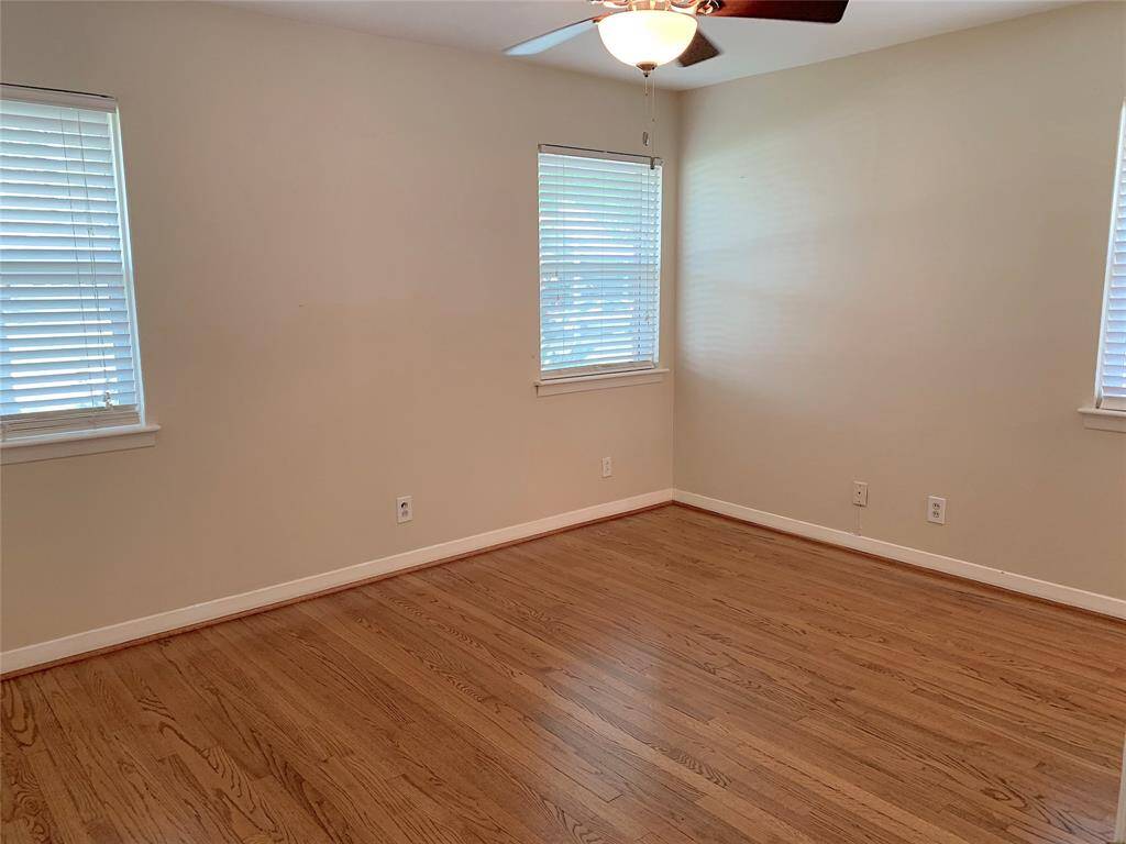 View of Primary bedroom. All bedrooms have ceiling fans and hardwood floors.