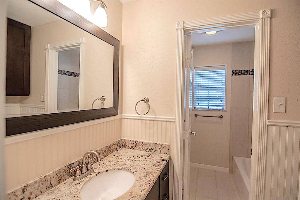 Doorway leading to guest bathtub. Linen cabinet.