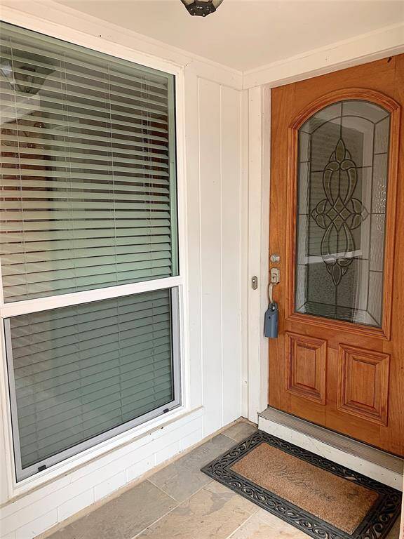 Tiled front porch with glass front door.