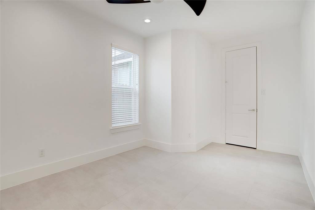The downstairs secondary bedroom, complete with a closet and full ensuite bath. The sleek tile flooring makes for easier cleaning-- there is no carpet in this home.