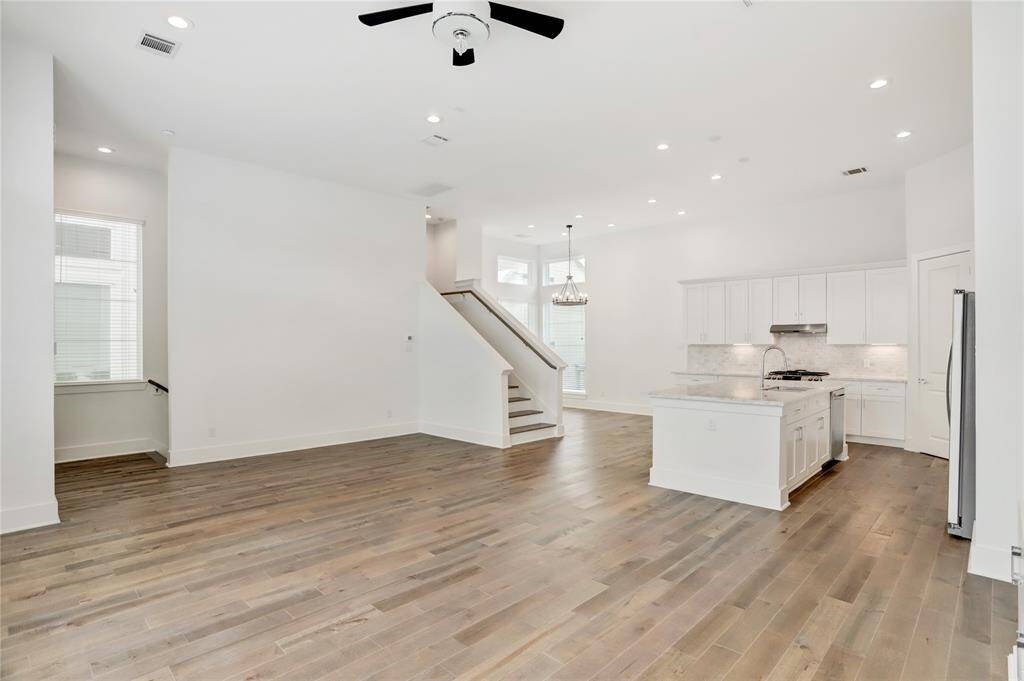 Looking from the entertainment area back toward the kitchen and dining areas. The stairs on the left lead down to the foyer, and the stairs in the center lead up to rest of the bedrooms.
